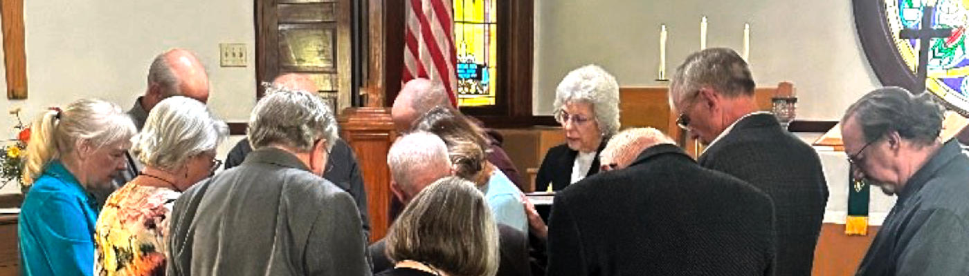 Session members with their heads bowed in prayer